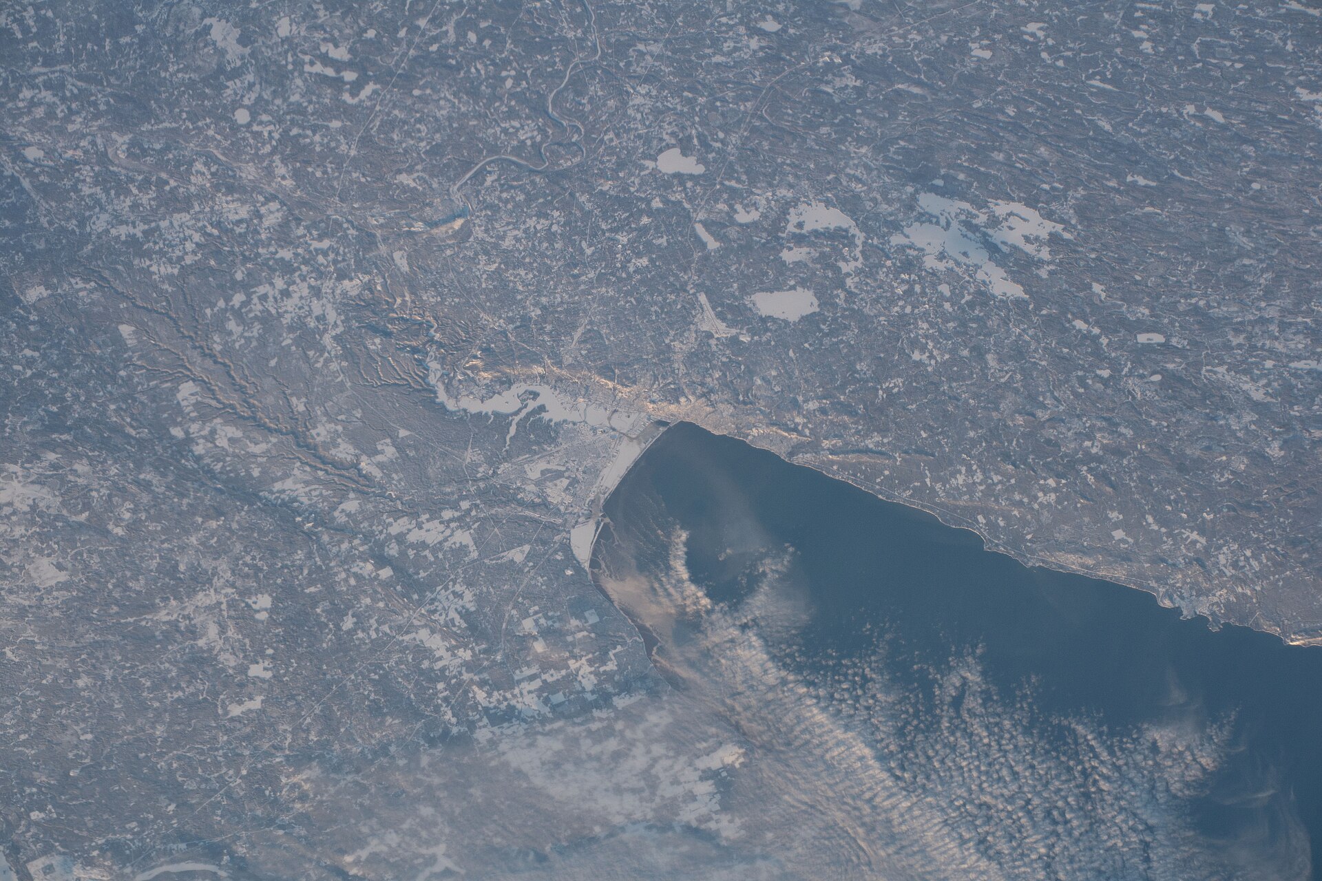 The head of Lake Superior photographed from orbit in winter, with the frozen St. Louis River and the Duluth and Superior shoreline picked out in snow