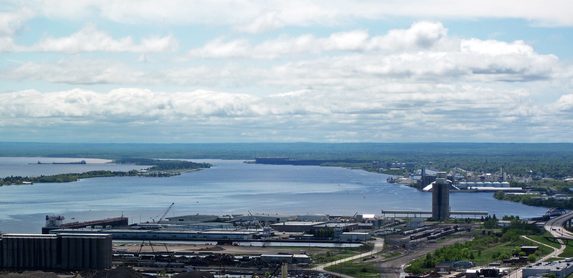 The St. Louis River estuary spread out below a high overlook, with the waterfront, rail yards and the far shore beyond
