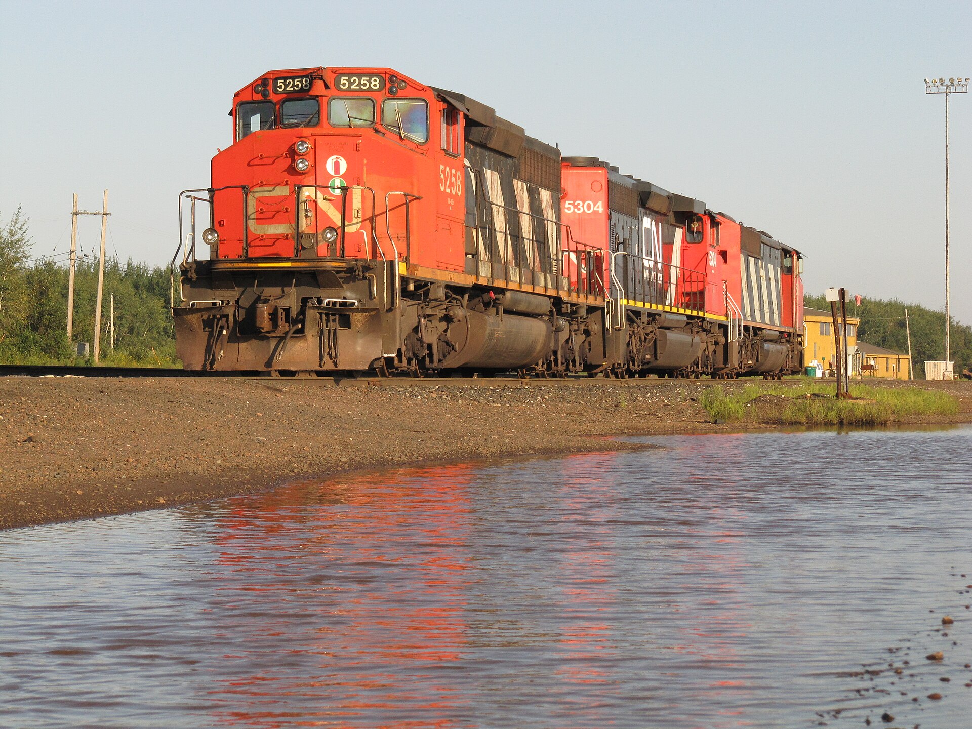 Two red Canadian National diesel locomotives standing in the rail yard at Proctor, Minnesota, in low evening light